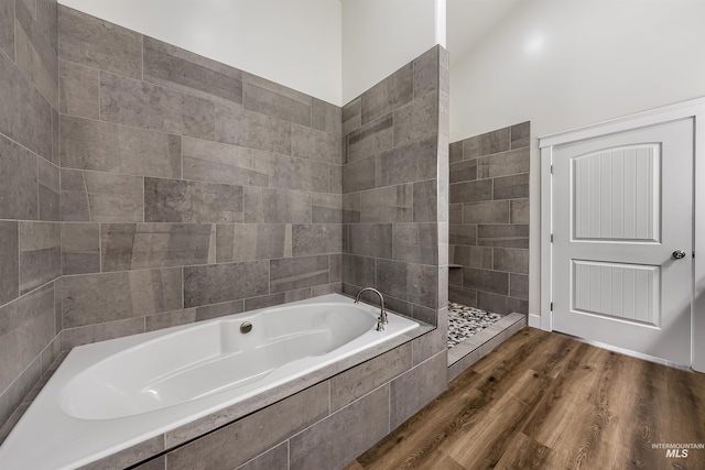 bathroom featuring wood finished floors and a garden tub