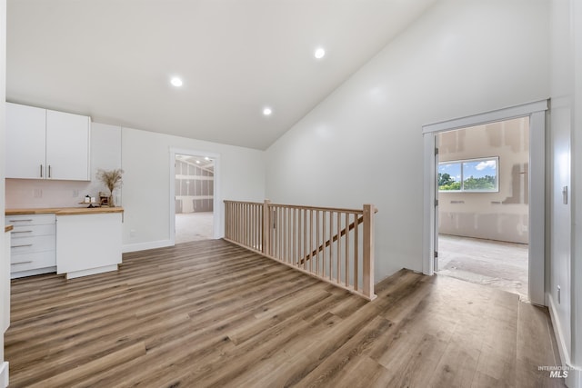 interior space with high vaulted ceiling, recessed lighting, and light wood-style floors