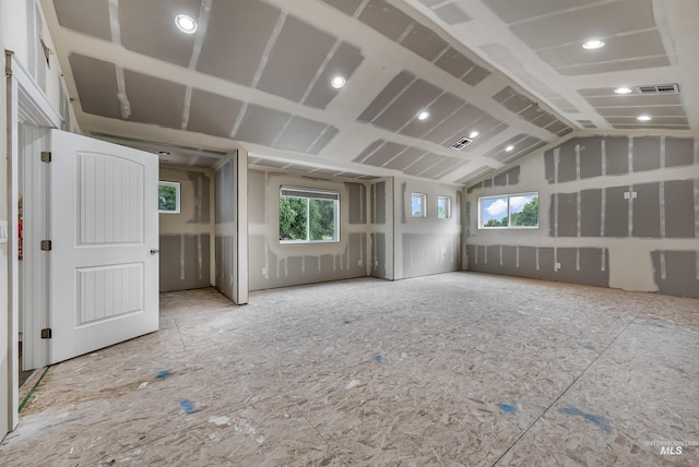 empty room featuring lofted ceiling and visible vents