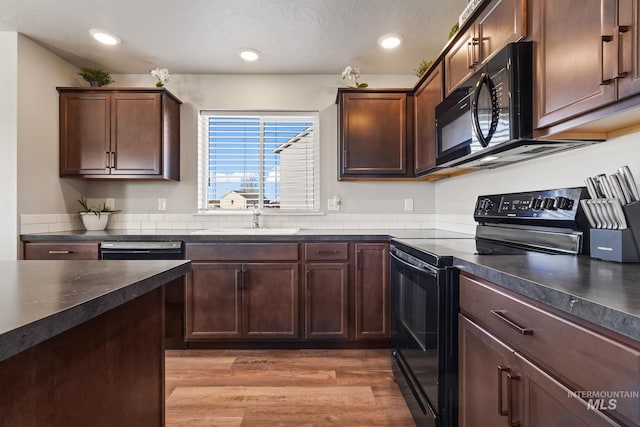 kitchen with light hardwood / wood-style floors, sink, dark brown cabinets, and black appliances