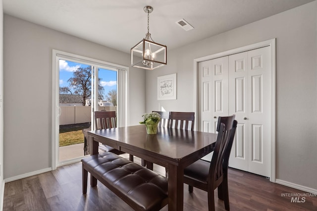 dining space featuring dark hardwood / wood-style floors and a chandelier