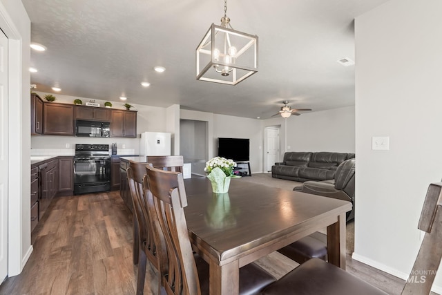 dining space with ceiling fan and dark hardwood / wood-style flooring