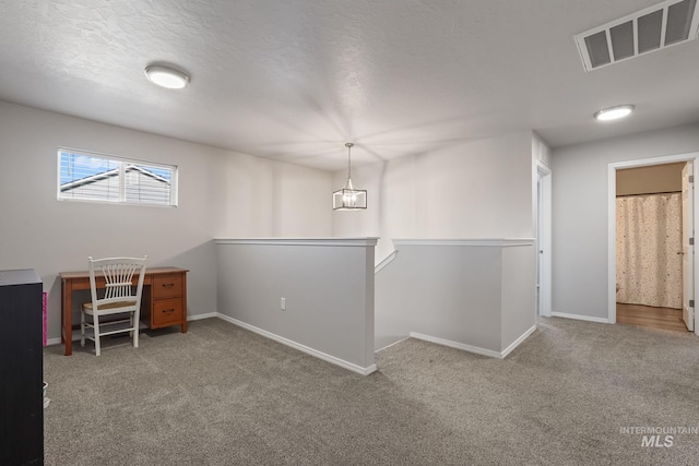 unfurnished office featuring a textured ceiling and carpet