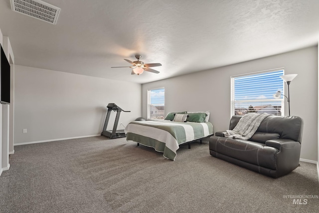 bedroom featuring ceiling fan, carpet floors, and a textured ceiling