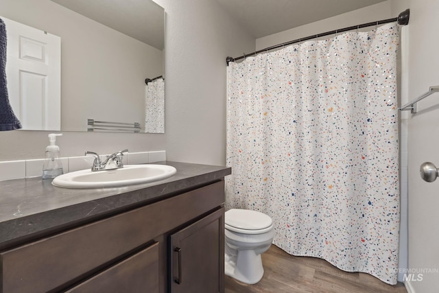 bathroom featuring wood-type flooring, vanity, and toilet