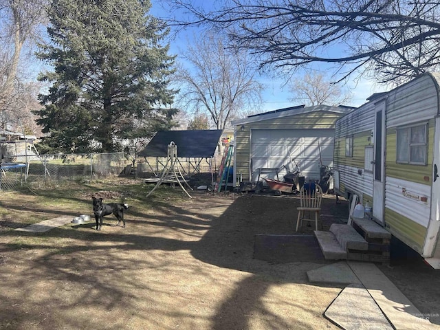 view of yard with a garage, entry steps, and fence