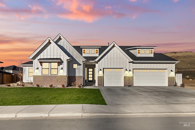 modern farmhouse featuring a garage and a lawn