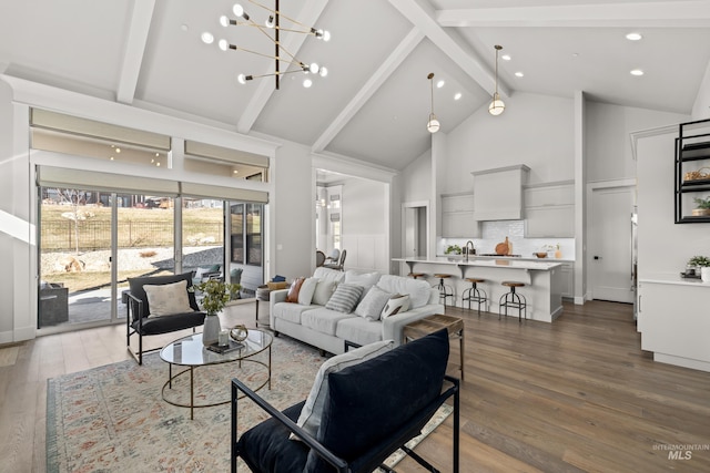 living room with a chandelier, hardwood / wood-style flooring, high vaulted ceiling, and beam ceiling