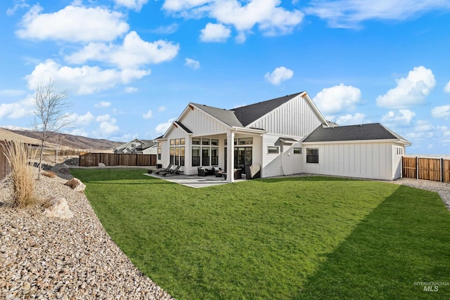 rear view of property with a yard and a patio