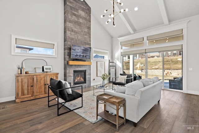 living room with a towering ceiling, beamed ceiling, dark hardwood / wood-style flooring, and a tiled fireplace