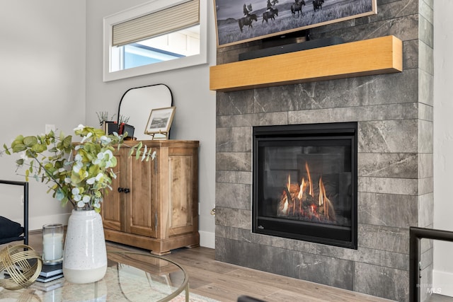 interior details featuring hardwood / wood-style flooring and a tile fireplace