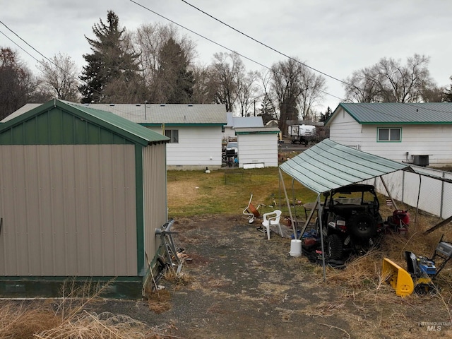 view of yard featuring central AC, a carport, and an outdoor structure