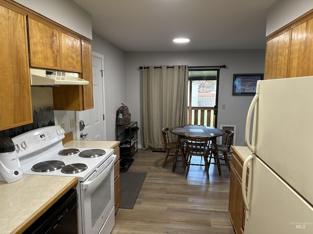 kitchen with white appliances, light wood-type flooring, light countertops, under cabinet range hood, and brown cabinets