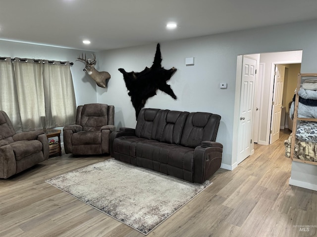 living area featuring recessed lighting, baseboards, and light wood-style flooring
