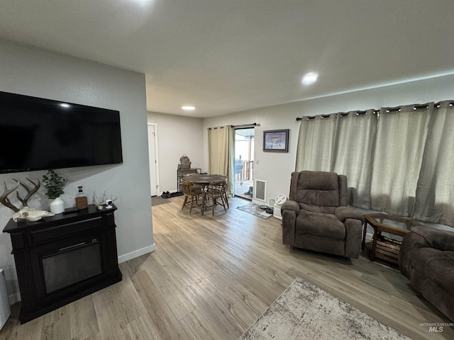 living room featuring recessed lighting, baseboards, and light wood finished floors