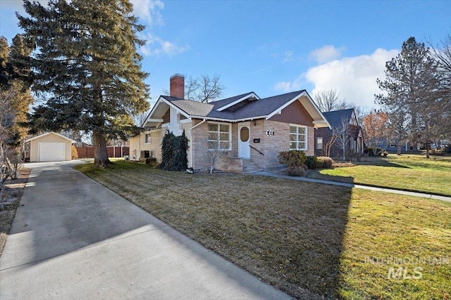 view of front of house with a front lawn, a garage, and an outbuilding