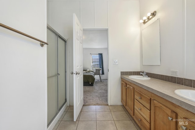 bathroom with vanity, a shower with door, and tile patterned flooring