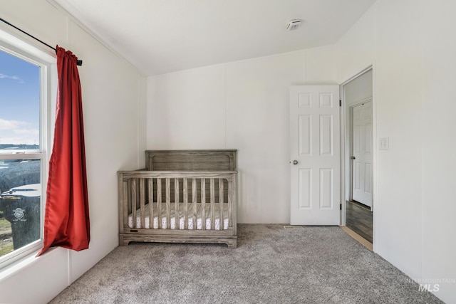 unfurnished bedroom featuring carpet floors and a nursery area