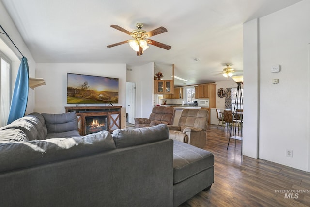 living room featuring dark hardwood / wood-style flooring, vaulted ceiling, and ceiling fan