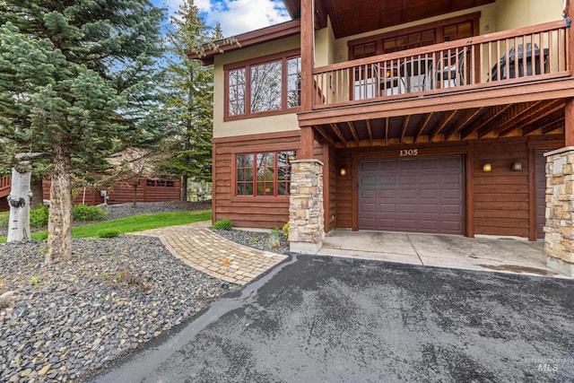 1305 Greystone, Mccall, ID 83638 - view of front of home featuring a garage, asphalt driveway, and a balcony
