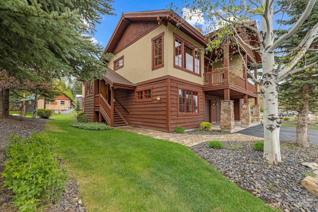 1305 Greystone, Mccall, ID 83638 - view of side of home featuring a balcony, a lawn, stucco siding, and stairway