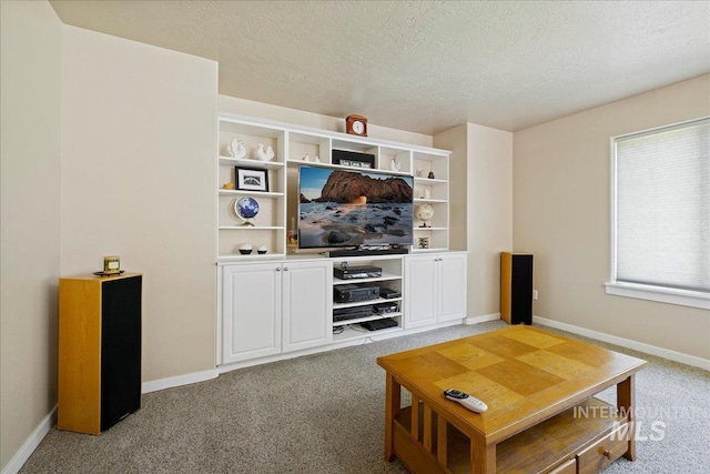 living room featuring light carpet, a textured ceiling, and baseboards