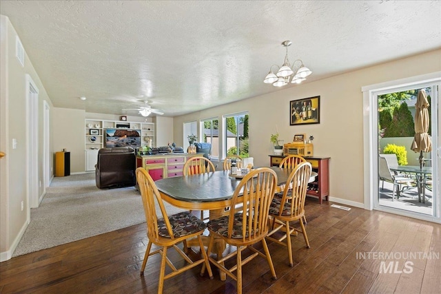 dining room featuring dark wood-style floors, a textured ceiling, baseboards, and ceiling fan with notable chandelier