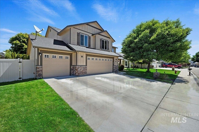 view of front of home with fence, stone siding, concrete driveway, a gate, and a front lawn