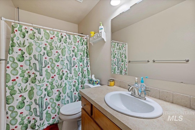 bathroom with toilet, curtained shower, and vanity