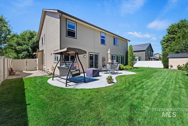 back of house featuring a yard, a fenced backyard, and a patio