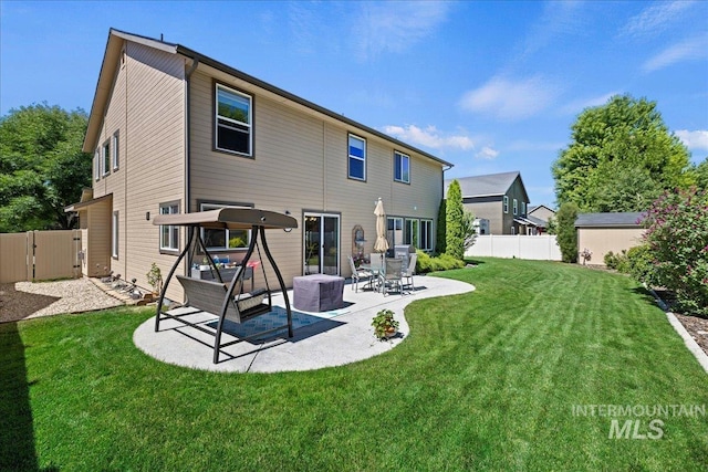 rear view of property with a patio area, a fenced backyard, a gate, and a yard