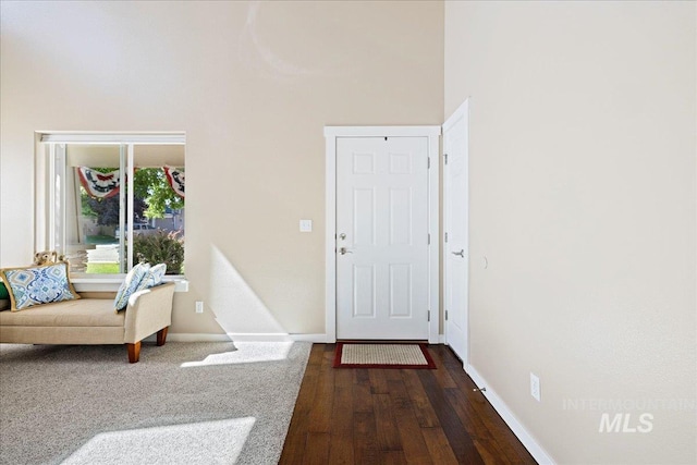 foyer entrance with dark wood-style flooring and baseboards