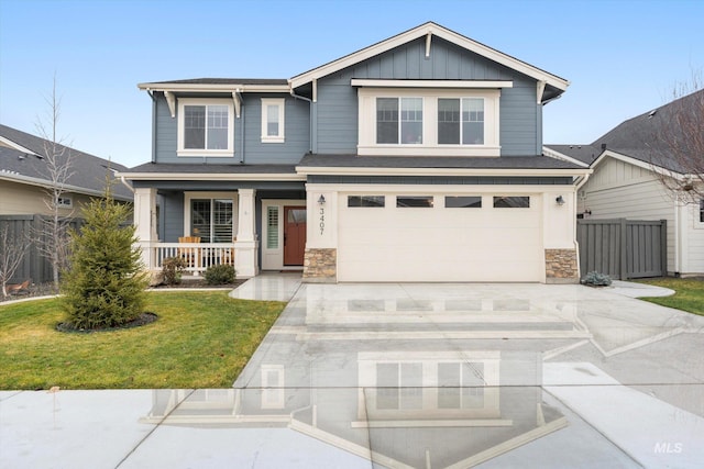 craftsman inspired home with covered porch, a garage, and a front lawn