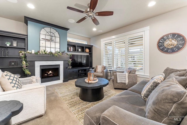 living room with a fireplace, carpet flooring, and ceiling fan