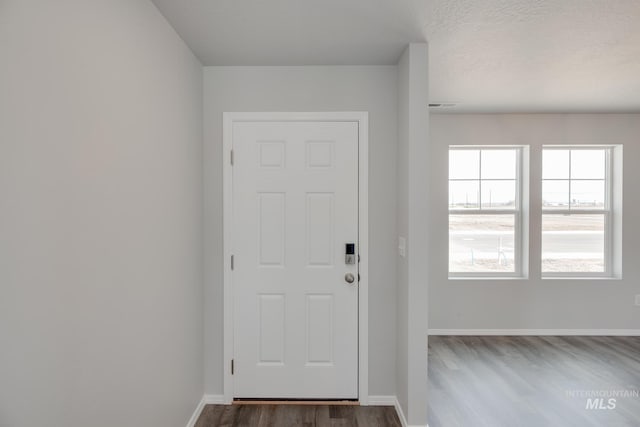 entryway with a textured ceiling and dark hardwood / wood-style flooring