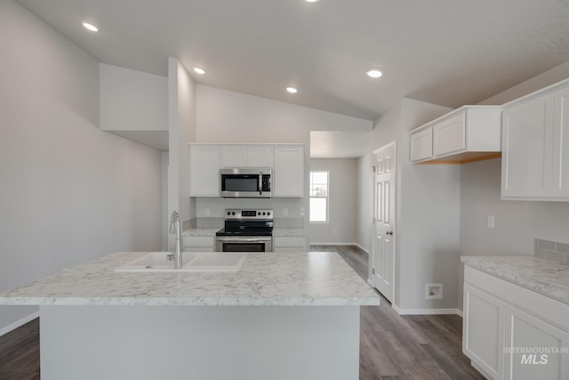 kitchen featuring lofted ceiling, white cabinets, stainless steel appliances, and an island with sink