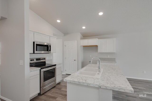 kitchen featuring stainless steel appliances, sink, an island with sink, and white cabinets