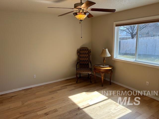 unfurnished room with a ceiling fan, baseboards, and wood finished floors