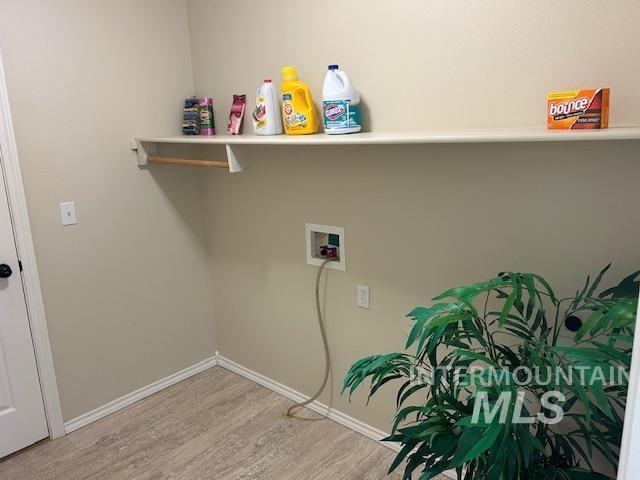 laundry room featuring hookup for a washing machine, baseboards, wood finished floors, and laundry area