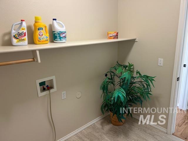 laundry room with baseboards, wood finished floors, hookup for a washing machine, and laundry area