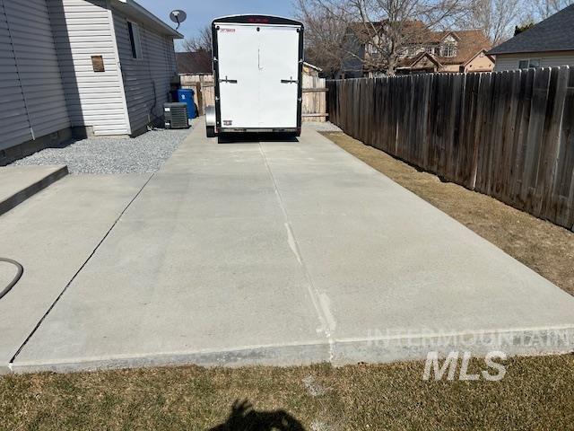 view of storm shelter featuring a patio area, central AC, and fence