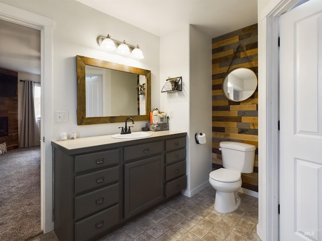 bathroom with wood walls, vanity, and toilet