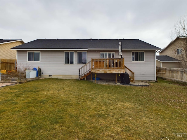 rear view of house featuring a lawn and a deck