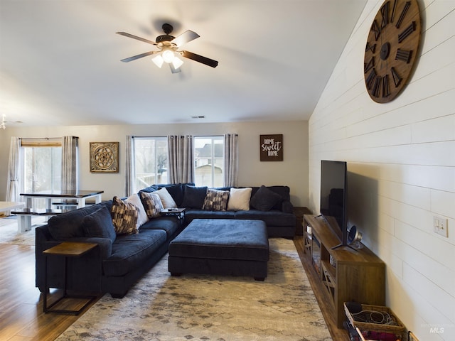 living room featuring ceiling fan, wood-type flooring, and vaulted ceiling