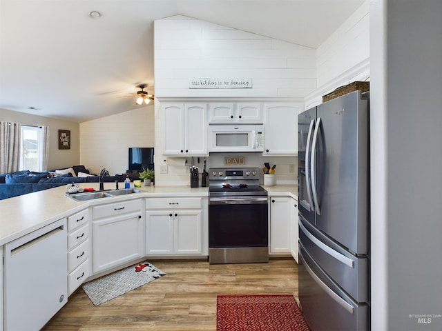 kitchen featuring stainless steel appliances, lofted ceiling, and sink