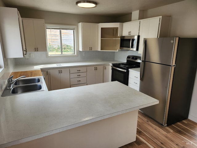 3004/3006 W Gerrard St, Boise, ID 83703 - kitchen featuring appliances with stainless steel finishes, a peninsula, dark wood-style floors, open shelves, and light countertops