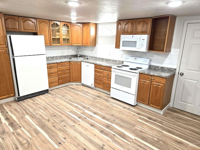 3004/3006 W Gerrard St, Boise, ID 83703 - kitchen featuring white appliances, brown cabinets, light wood-style flooring, decorative backsplash, and a textured ceiling