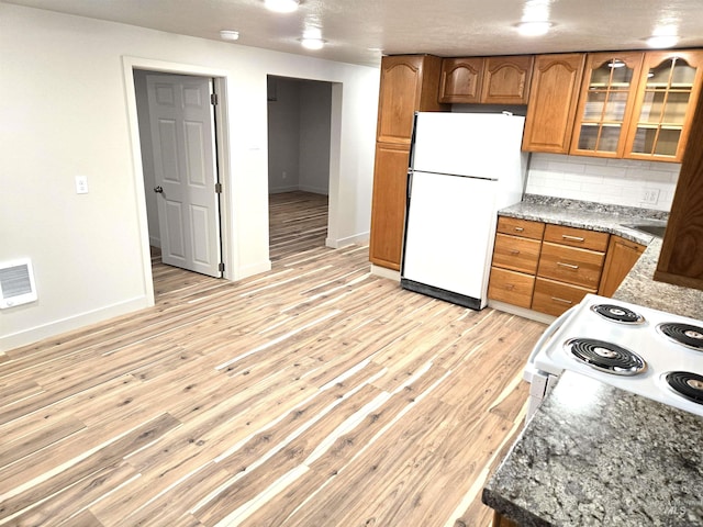 3004/3006 W Gerrard St, Boise, ID 83703 - kitchen with white appliances, brown cabinetry, backsplash, glass insert cabinets, and light wood-style floors