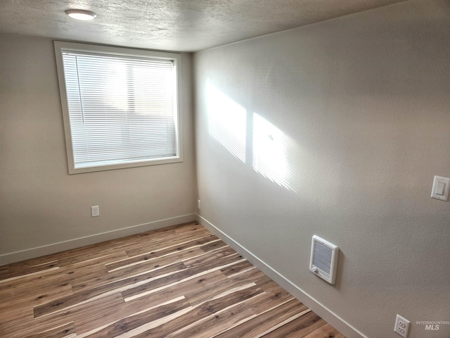 3004/3006 W Gerrard St, Boise, ID 83703 - empty room featuring wood finished floors, a textured ceiling, and heating unit