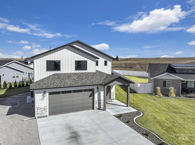 view of front of house featuring driveway, roof with shingles, a front yard, and fence